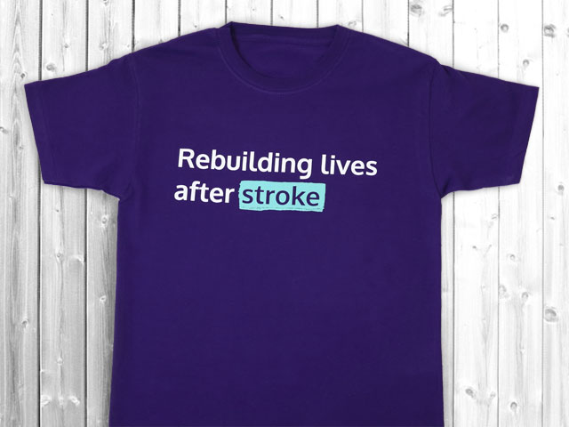 Purple rebuilding lives after stroke t-short on a white wooden background